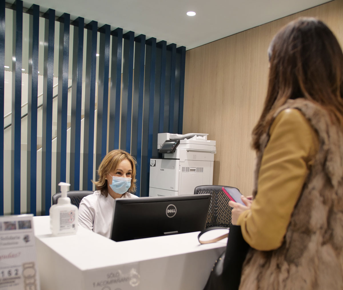 Una profesional del ICQO atiende a una paciente en la recepción de la clínica.